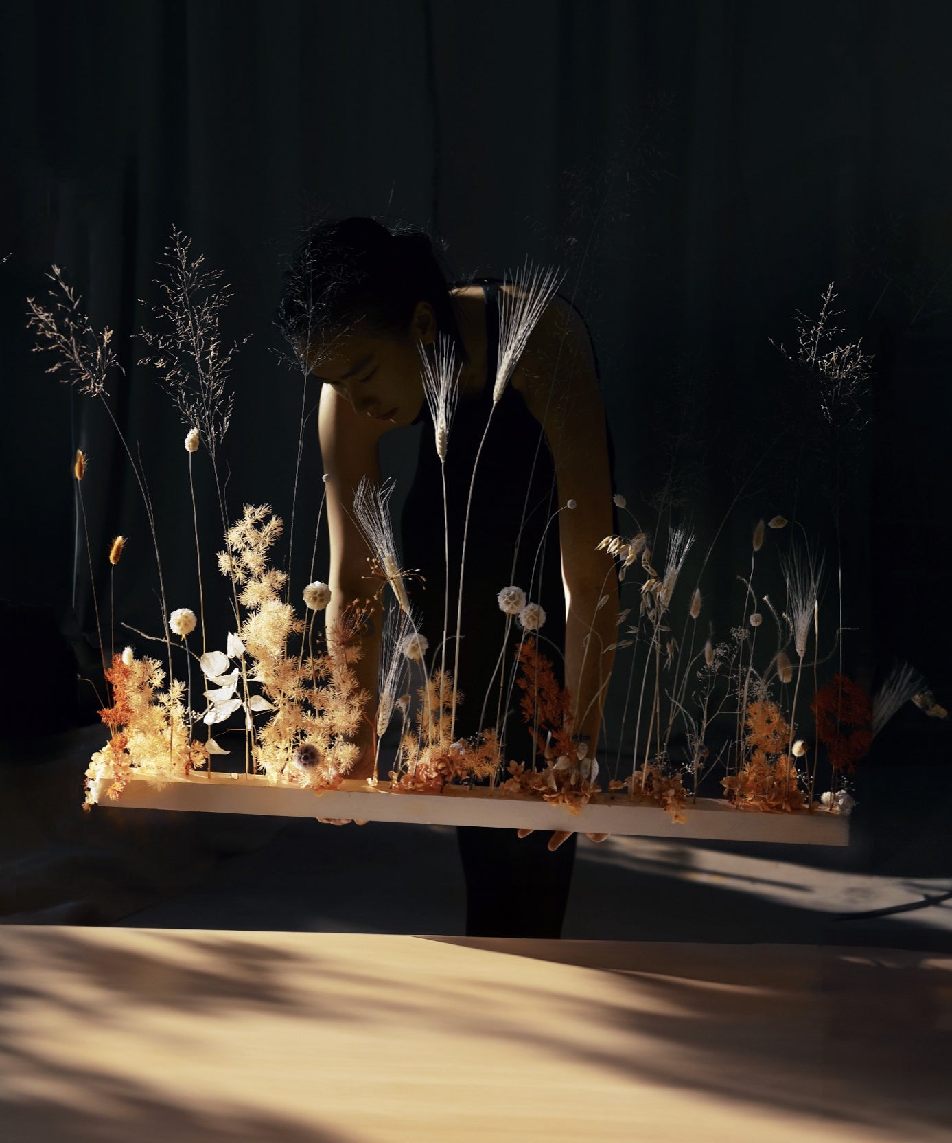 A long dried botanical composition being built in the atelier