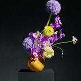 Allium, vanda orchid and green chrysanthemum in an ochre vessel